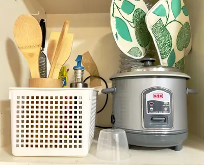 a kitchen counter with a slow cooker and a clock at Althea's Cozy Home - Condo in Las Pinas in Manila