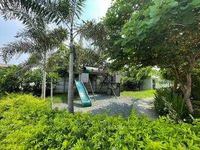 a playground with a slide in a yard with trees at Althea's Cozy Home - Condo in Las Pinas in Manila