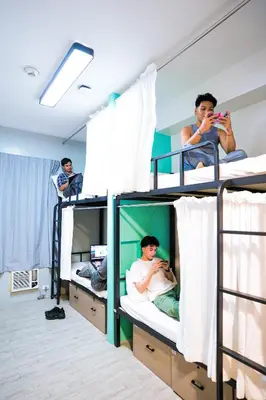 a group of men in bunk beds in a room at The City Flats Sacred Heart in Manila