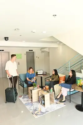 a group of people sitting in a waiting room at The City Flats Sacred Heart in Manila