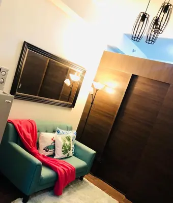 a room with a green couch with a red blanket on it at Air residence 1BR with balcony FREE NETFLIX in Manila