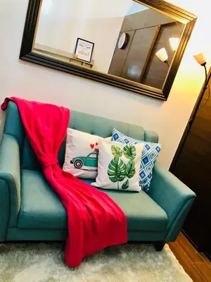a blue couch with a red blanket on it at Air residence 1BR with balcony FREE NETFLIX in Manila