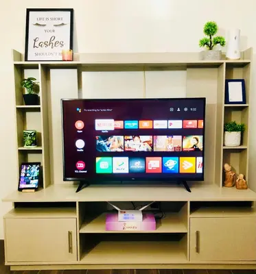 a flat screen tv sitting on top of a shelf at Air residence 1BR with balcony FREE NETFLIX in Manila