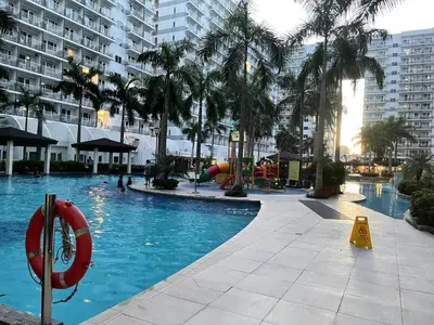 a swimming pool with a playground and a water slide at Amour Staycation Shell residences in Manila