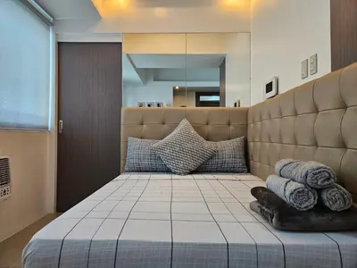 a bedroom with a large bed with pillows on it at Spacious Studios in Manila