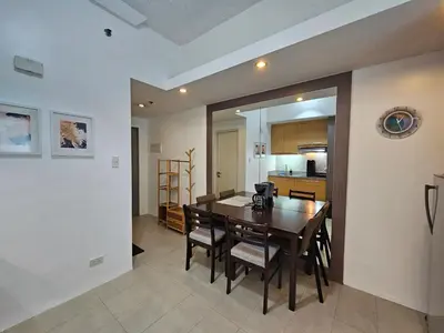 a kitchen and dining room with a table and chairs at Spacious Studios in Manila