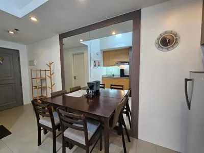 a kitchen and dining room with a wooden table and chairs at Spacious Studios in Manila