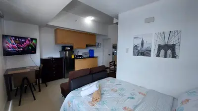 a small room with a bed and a kitchen at Spacious Studios in Manila