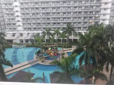 an aerial view of a resort swimming pool with a large building at vin's place 1br amenities view at Shell Residence in Manila