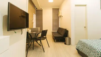 a room with a bed and a table and a television at SOUTHPICKRESORT & HOTEL INC. in Aplaya