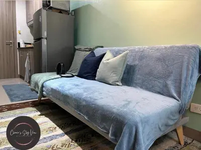 a blue couch with pillows on it in a room at SMDC Coast Residences near PICC in Manila