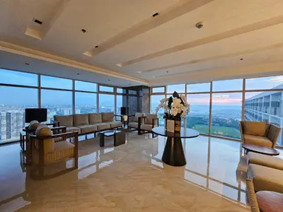 a living room with couches and tables and windows at SMDC Coast Residences near PICC in Manila