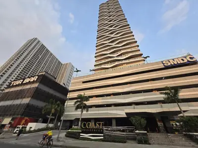 a large building with a sign in front of it at SMDC Coast Residences near PICC in Manila