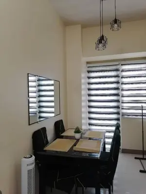 a dining room with a table and chairs and windows at Pasay Coast Residences JCMJ in Manila