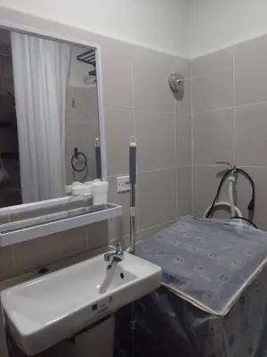 a bathroom with a hospital bed and a sink at Pasay Coast Residences JCMJ in Manila