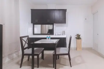 a dining room with a table and two chairs at Propiedad Residences Makati in Manila