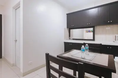 a kitchen with a table with two bottles on it at Propiedad Residences Makati in Manila