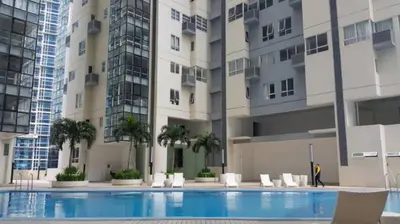 a swimming pool in front of a building at 2 BR loft-type condo Fort Victoria in Manila