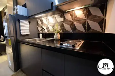 a kitchen with a sink and a stainless steel refrigerator at DM's Place at S Residences MOA in Manila