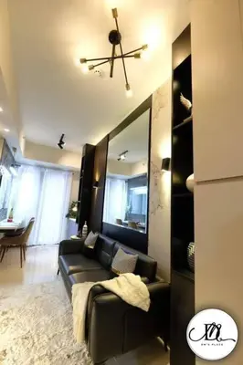 a living room with a black couch and a ceiling fan at DM's Place at S Residences MOA in Manila