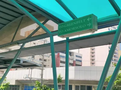 a green street sign in front of a building at Great View 1 BR Condo in Makati near Trident Tower in Manila