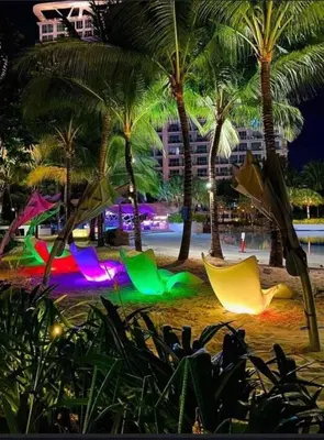 a beach with chairs and palm trees at night at Azure Urban Resort Residence A1 in Manila
