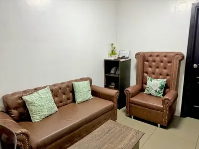 a living room with a couch and a chair at 2BR w Balcony in Araneta, Cubao w Pool and Gym - Porto Vita in Manila