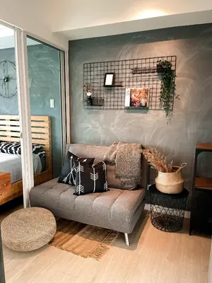 a living room with a couch with pillows on it at Downtown Nook - Azure Urban Resort Residences in Manila