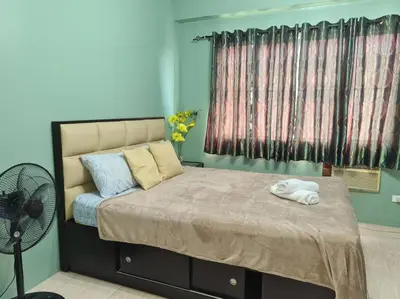 a bedroom with a bed with a fan and a window at Affordable staycation in Valleygolf in Cainta