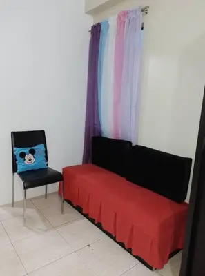 a red couch and a chair in a room at Affordable Transient along Ortigas Ext in Cainta