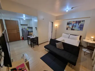 a living room with a bed and a couch at Palm Tree Villas Condominium by Beth in Manila