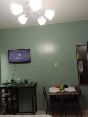 a living room with two tables and a tv on the wall at Affordable Staycation in Valley Mansions near Sitio Elena Events Place in Cainta