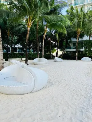 a white bed on the beach with palm trees at Azure Pool View with Balcony, WiFi and Netflix in Manila