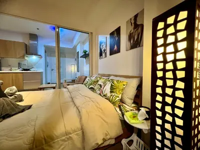 a bedroom with a bed and a living room at Azure Pool View with Balcony, WiFi and Netflix in Manila