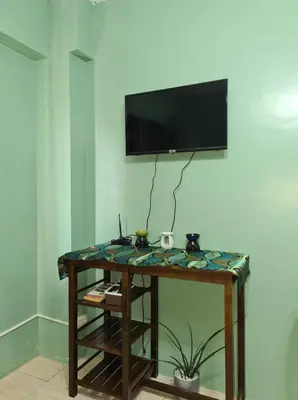 a room with a table with a television on a wall at Pet Friendly Condo for Rent along Ortigas Ext near Cainta/ Pasig in Cainta