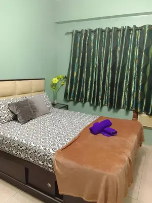 a bedroom with a bed with purple gloves on it at Pet Friendly Transient in Valley Golf near Emperor Events Place in Cainta