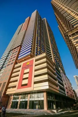 a tall building with a red sign on it at Roxas Blvd Stunning Studio Condo Near US Embassy in Manila