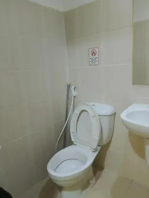 a bathroom with a toilet and a sink at Roxas Blvd Stunning Studio Condo Near US Embassy in Manila