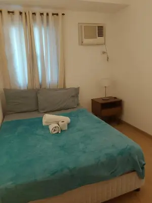 a bedroom with a bed with two towels on it at Roxas Blvd Stunning Studio Condo Near US Embassy in Manila