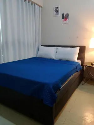 a bed in a room with a blue blanket on it at Roxas Blvd Stunning Studio Condo Near US Embassy in Manila