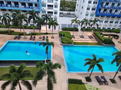an overhead view of a swimming pool in a resort with palm trees at 5 Years Legit Staycation Infront Of Moa, Sea Residences Tower A, Near Smx, Arena, Dfa, World Trade, PICC, AYALA MALL, NAIA in Manila