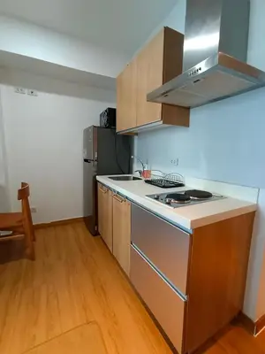 a kitchen with a stove top oven next to a refrigerator at Happirest at Azure Urban Resort Residences, Paranaque City in Manila