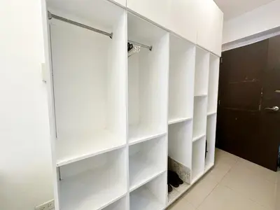 a white walk in closet with white shelves at King Bed Suite at Pine Crest #T3-439 near Mall in Manila