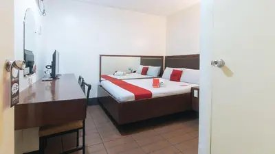 a bedroom with a bed and a desk with a television at RedDoorz @ Riches Holiday Hotel Avenida in Manila