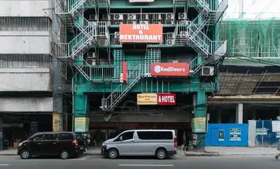 two cars are parked in front of a building at RedDoorz @ Riches Holiday Hotel Avenida in Manila