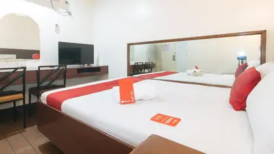 a hotel room with two beds and a television at RedDoorz @ Riches Holiday Hotel Avenida in Manila