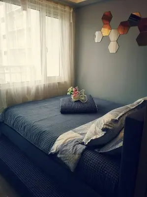 a bedroom with a bed with a window and a bowl of flowers at Serenity Cove MOA in Manila