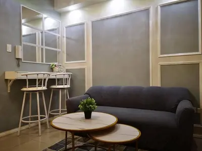 a living room with a blue couch and a table at Serenity Cove MOA in Manila