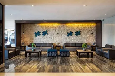 a lobby with couches and tables in a building at Serenity Cove MOA in Manila