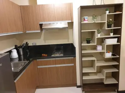 a kitchen with wooden cabinets and a sink and shelves at The Radiance by Dominga in Manila